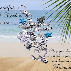May include: A silver-toned crystal anchor charm with various sea-themed charms, including starfish, seahorses, and a turtle. The text "Beautiful Crystal Anchor Charm" is displayed above the charm. The background shows a beach scene.
