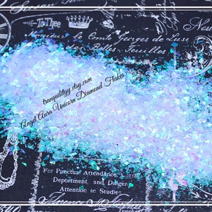 Könnte beinhalten: Nahaufnahme von schimmernden blauen und grünen Glitterflocken. Der Glitter ist auf einem schwarzen Hintergrund mit weißem Text verteilt, der "tranquilityy.etsy.com Angel Aura Unicorn Diamond Flakes" lautet.