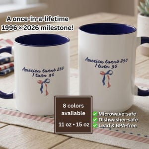 May include: Two white ceramic mugs with navy blue accents. The mugs have the text "America turns 250, I turn 30" and a ribbon graphic. One mug is 11 oz, the other is 15 oz. The image also includes text that says "8 colors available" and "Microwave-safe, Dishwasher-safe, Lead & BPA-free."