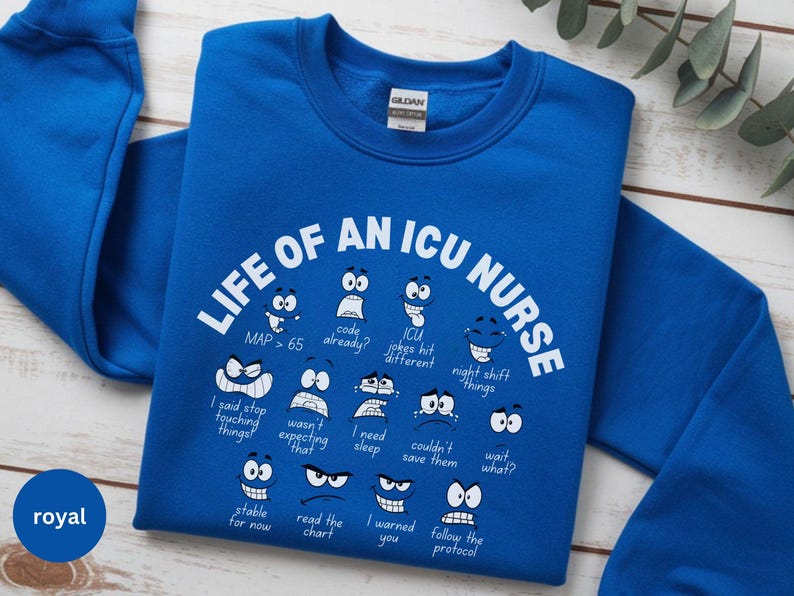 May include: Royal blue sweatshirt with the text "LIFE OF AN ICU NURSE" and various cartoon faces expressing different emotions. The sweatshirt also includes phrases like "MAP > 65" and "I need sleep."
