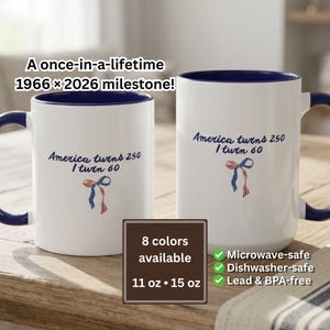 May include: Two white ceramic mugs with dark blue interiors and handles. The text reads: A once-in-a-lifetime 1966 x 2026 milestone! America turns 250 I turn 60. Below the text is a small red, white, and blue ribbon graphic. Available in 11 oz and 15 oz.