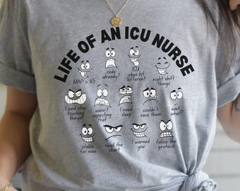 May include: Athletic heather gray t-shirt with the text "LIFE OF AN ICU NURSE" and various cartoon faces expressing different emotions. The shirt also includes phrases like "MAP > 65" and "I warned you".