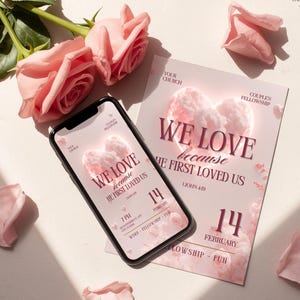 Puede incluir: Un teléfono inteligente y un folleto con el texto "WE LOVE because HE FIRST LOVED US" se muestran con rosas y pétalos rosas. El folleto y la pantalla del teléfono presentan un diseño en forma de corazón. También es visible la fecha "14 de febrero".