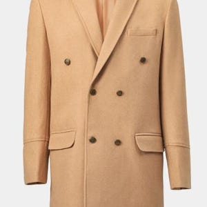 Op de afbeelding: Een beige double-breasted overjas met een reverskraag, twee voorzakken en vier knopen. De jas heeft een getailleerde pasvorm en een klassiek ontwerp, geschikt voor formele of zakelijke kleding.