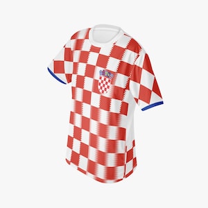May include: A white and red checkered t-shirt with a Croatian coat of arms on the chest. The shirt has a crew neck, short sleeves with blue trim, and a red and white checkered pattern.