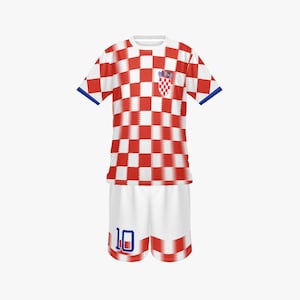 May include: A Croatia soccer uniform set, featuring a red and white checkered jersey with blue trim and a Croatian coat of arms emblem. The matching white shorts have the number 10 in blue. The kit is designed for sports.