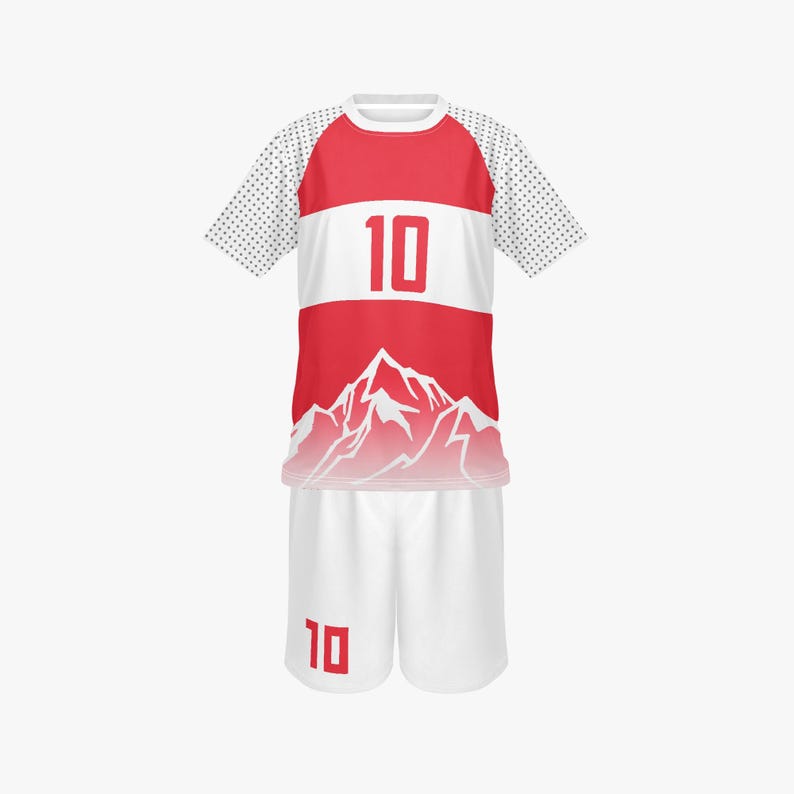 May include: A red and white soccer uniform set. The jersey has a red upper section, a white stripe with the number 10, and a mountain graphic. The sleeves are white with black dots. The shorts are white with the number 10.