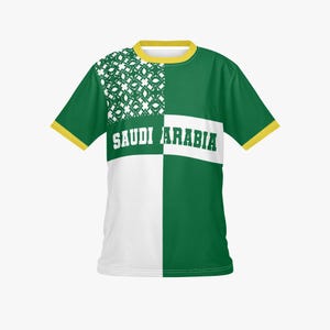 以下が含まれることがあります： サウジアラビアの国旗をモチーフにした、ツートンカラーの半袖Tシャツ。緑と白を基調とし、中央に白字で「SAUDI ARABIA」と書かれています。襟と袖口は黄色です。