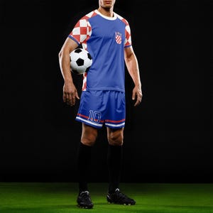 May include: A blue soccer uniform with red and white accents, featuring a Croatian flag design. The jersey has a white collar and red and white checkered sleeves. The shorts have the number 10. A soccer ball is held in the image.
