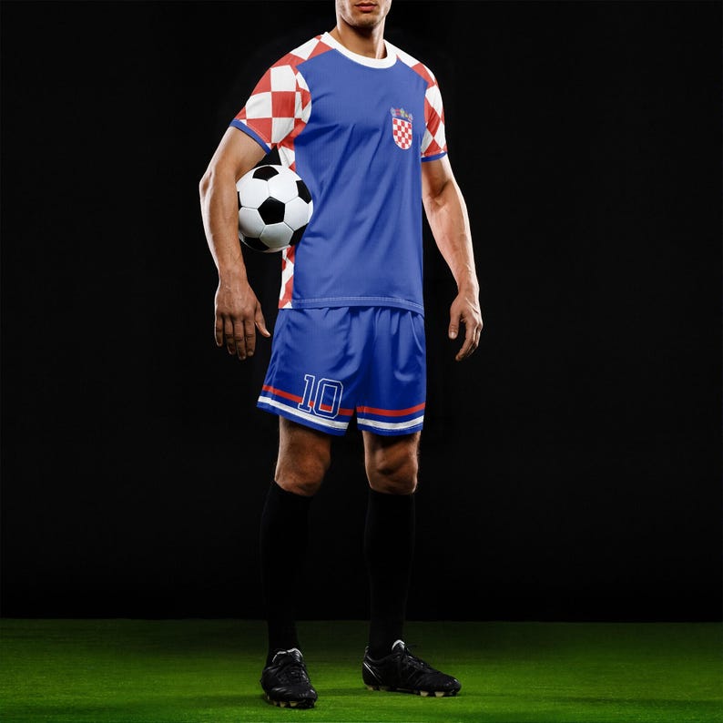 May include: A blue soccer uniform with red and white accents, featuring a Croatian flag design. The jersey has a white collar and red and white checkered sleeves. The shorts have the number 10. A soccer ball is held in the image.