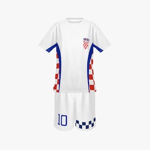 Peut inclure: Un uniforme de football blanc avec des d&eacute;tails bleus et rouges. Le maillot arbore un &eacute;cusson du drapeau croate et des bordures bleues. Le short affiche le num&eacute;ro 10 en bleu. L'ensemble pr&eacute;sente un motif &agrave; carreaux.