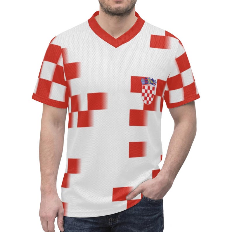 Op de afbeelding: Wit V-hals T-shirt met een rood-wit geblokt patroon. Het shirt heeft het Kroatische wapen op de borst. De mouwen en de halslijn zijn rood afgewerkt. Het ontwerp is gepixeld.