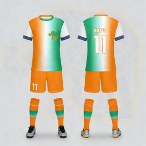 Op de afbeelding: Een complete voetbalset in oranje, wit en groen. Het shirt heeft een olifantafbeelding en het nummer 11. Inclusief shorts, sokken en schoenen. De mouwen en sokken hebben een blauwe patroonafwerking.