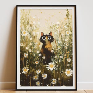 Op de afbeelding: Een ingelijste kunstdruk met een illustratie van een kat in een veld met madeliefjes. De kat heeft grote, ronde ogen en een schildpadpatroon. De madeliefjes hebben witte bloemblaadjes en gele centra tegen een zachte, neutrale achtergrond.