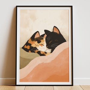 May include: A framed art print featuring two cats. One cat is black, and the other is calico with orange, brown, and black markings. They are nestled together, with their heads touching, against a backdrop of soft, muted colors.