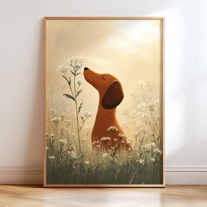 Puede incluir: Una impresión artística enmarcada que presenta un perro salchicha de dibujos animados en un campo de flores blancas. El perro, con pelaje marrón y una oreja oscura, está oliendo una flor. El fondo es un degradado suave y cálido de amarillo y beige.