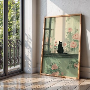 May include: A framed art print featuring a black cat perched on a windowsill. The artwork depicts a window with floral curtains and a pot of pink roses. The frame is made of light-colored wood, and the overall aesthetic is soft and inviting.