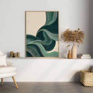May include: An abstract art print with a wooden frame. The artwork features flowing, layered brushstrokes in shades of green and teal against a beige background. The print is displayed above a white shelf with decorative items.