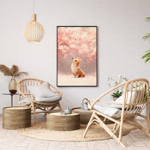 Puede incluir: Una impresi&oacute;n art&iacute;stica enmarcada que presenta una pintura a la acuarela de un perro corgi mirando hacia arriba a las flores de cerezo rosas. La obra de arte est&aacute; ambientada sobre un fondo suave y nevado. La impresi&oacute;n se exhibe en un sal&oacute;n con muebles de mimbre.