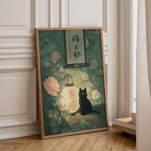 May include: Framed art print featuring a black cat sitting near a glowing lantern with Japanese text. The artwork has a vintage aesthetic, with a backdrop of flowers and foliage in shades of green and pink. The frame is a natural wood color.