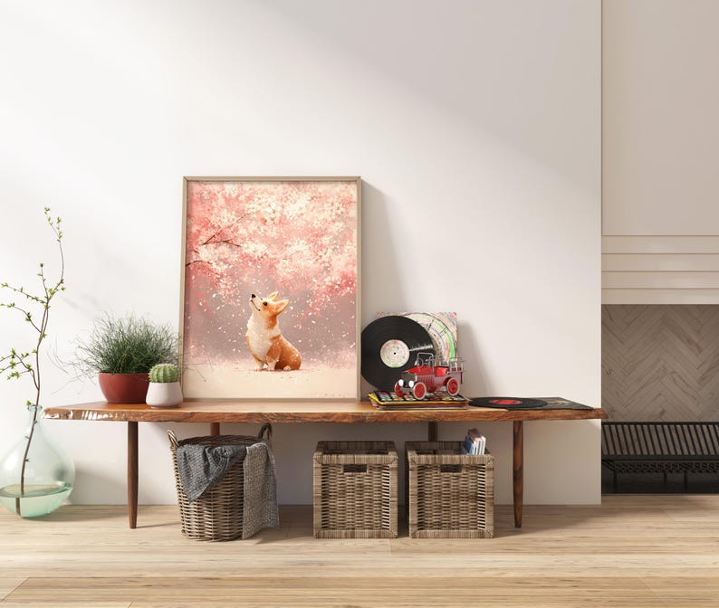 Puede incluir: Una impresi&oacute;n art&iacute;stica enmarcada que representa a un perro corgi mirando hacia arriba a un &aacute;rbol en flor rosa. La obra de arte se exhibe en una consola de madera con objetos decorativos, incluyendo un tocadiscos y plantas en macetas.