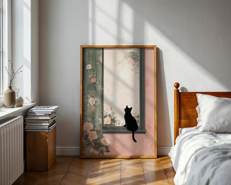 May include: A framed art print featuring a black cat silhouette perched on a window ledge. The artwork has a soft, pastel color palette with floral and botanical elements. The frame is a warm, natural wood tone, complementing the room's decor.
