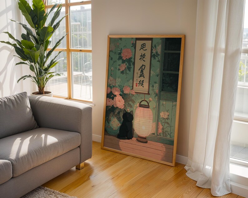 May include: A framed art print featuring a black cat, a paper lantern, and floral elements. The artwork is set against a backdrop of a window and a wall with floral patterns. The print has a wooden frame and is displayed on a wooden floor.