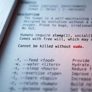 May include: A printed document featuring technical text about humans, including the lines "Cannot be killed without sudo." with the word "sudo" in red ink. The text lists command-line style arguments like "--feed <food>" and "--water <liters>."