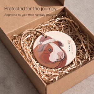 Personalized guinea pig Christmas ornament protected inside a kraft box with paper filling, ready for careful shipping after design approval.