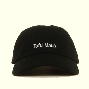 Könnte beinhalten: Eine schwarze Baseballkappe mit dem in weißem Garn auf die Vorderseite gestickten Text Tofu Maus. Die Kappe hat einen gebogenen Schirm und eine strukturierte Krone und präsentiert ein schlichtes Design mit kontrastreicher weißer Schrift.