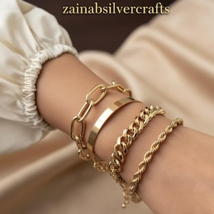 Puede incluir: Una colección de pulseras doradas de varios estilos. Las pulseras incluyen un eslabón de cadena, una banda plana, una cadena de bordillo y una cadena de cuerda. La imagen muestra las pulseras en una muñeca. El texto "zainabsilvercrafts" está en la parte superior.
