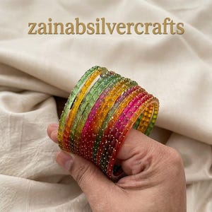 Paquete de 12 pulseras de cristal multicolor con detalles minimalistas de circonita cúbica.