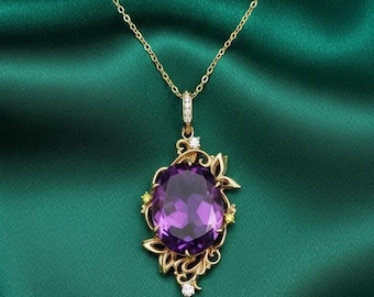 May include: A gold-colored necklace with a large, oval, purple gemstone pendant. The pendant is surrounded by a gold filigree design with small yellow and white accents. The necklace is displayed against a dark green background.
