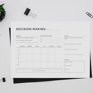 May include: A decision-making worksheet with the title "Decision Making" in a minimalist design. The worksheet includes sections for defining the decision, possible options, and aligning with goals. A black pen, pencils, and binder clips are scattered around.