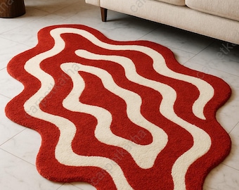 May include: A red and white wavy patterned rug. The rug has a unique, organic shape with a red background and white, flowing stripes. The rug is placed on a tiled floor near a beige sofa.