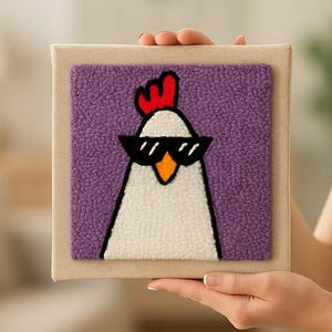 Op de afbeelding: Een vierkant kunstwerk met een beige lijst, met een kip met een zonnebril. De kip is wit met een zwarte omtrek, een rode kam en een paarse, getextureerde achtergrond. Een leuk en eigenzinnig kunstwerk.