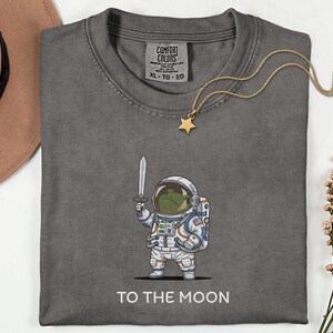 To The Moon Astronaut Frog Graphic Shirt, Funny Space Exploration Tee, NASA Artemis 2 Moon 2026 Humor Gift For Astronomy And Animal Lover image 2