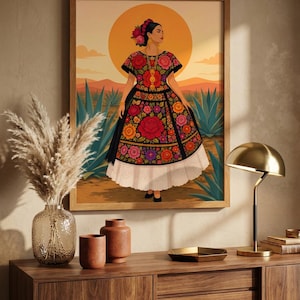 Puede incluir: Una lámina de arte mural enmarcada que muestra la ilustración de una persona con un vestido negro con bordados florales rojos, naranjas y rosas, un bajo de falda blanco y un accesorio floral en el pelo, sobre un paisaje desértico con un gran sol.