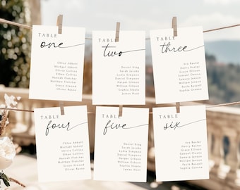 Può includere: Sei segnaposto rettangolari con nomi di ospiti sono appesi a una corda con mollette di legno. Ogni biglietto è numerato con una scrittura elegante. I biglietti sono color crema con testo nero, perfetti per un matrimonio o evento.