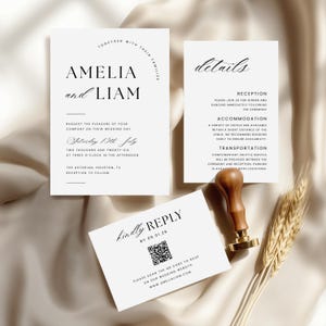 May include: A stylish wedding invitation suite with a minimalist design. The set includes an invitation, details card, and RSVP card. The invitation reads "Amelia and Liam" with event details. The RSVP card has a QR code. A wooden stamp and wheat are also present.