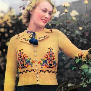 May include: Vintage yellow cardigan with colorful floral embroidery and a blue tassel detail. The image features the text "Specialty" and "No. 49". The cardigan is part of a vintage knitting pattern.