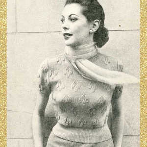 May include: A black and white photo of a woman wearing a knitted sweater with a floral pattern. The sweater has short sleeves and a scoop neck. The woman is wearing a scarf around her neck and has her hair pulled back. The photo is framed with a gold glitter border and the text "Subversive Femme" is written in cursive at the bottom.