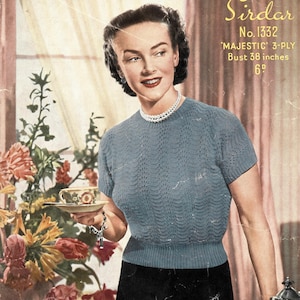 Può includere: Un modello di maglia vintage con una donna che indossa un maglione blu lavorato a maglia con una collana di perle. Il modello è per un maglione 'Majestic' 3 fili con una circonferenza del torace di 96,5 cm. Il modello è di Sirdar e ha il numero 1332.