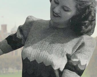 May include: A short-sleeved knit sweater featuring a multi-toned chevron pattern in shades of gray, white, and black. The garment has a round neckline, puffed sleeves, and a fitted waist, presented in a vintage-style photograph with a logo.
