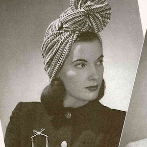 Puede incluir: Un sombrero de estilo turbante de patrón blanco y negro usado por una mujer con cabello oscuro. El sombrero está atado en un nudo en la parte superior y tiene un estilo suelto y fluido.