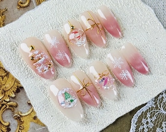 Presse-ongles amande festive en rose dégradé, nœuds dorés, flocons de neige, père Noël et arbres de Noël, faux ongles pour les fêtes de fin d'année et l'hiver
