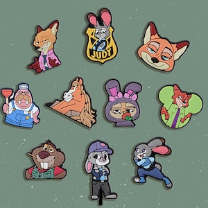 May include: A collection of colorful cartoon character charms, including a fox, a rabbit, a horse, and a beaver. The charms are in various poses and outfits, with some wearing police uniforms. The background is a solid green color.