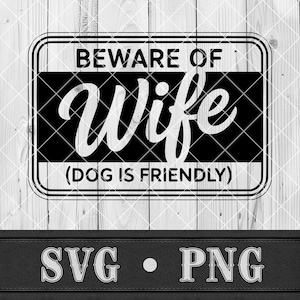 Op de afbeelding: Een zwart-wit bord met de tekst "BEWARE OF WIFE" in vette letters, met "(DOG IS FRIENDLY)" eronder. Het bord is rechthoekig met afgeronde hoeken, tegen een lichte houten achtergrond. Onder het bord staan de letters "SVG • PNG".