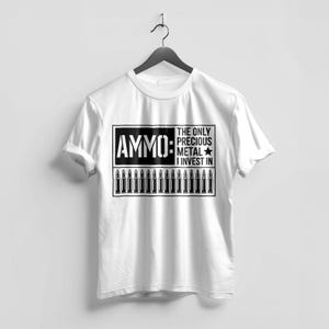 May include: White t-shirt with a black graphic. The graphic features the word "AMMO" in bold letters, a row of bullets, and the text "THE ONLY PRECIOUS METAL I INVEST IN". The shirt is hanging on a black hanger.