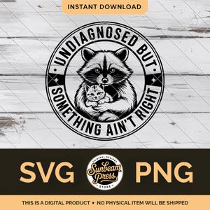 May include: A digital design in black and white, showing a raccoon embracing a kitten, with the text "UNDIAGNOSED BUT SOMETHING AIN'T RIGHT" in a circular frame. Includes "SVG" and "PNG" file type options.